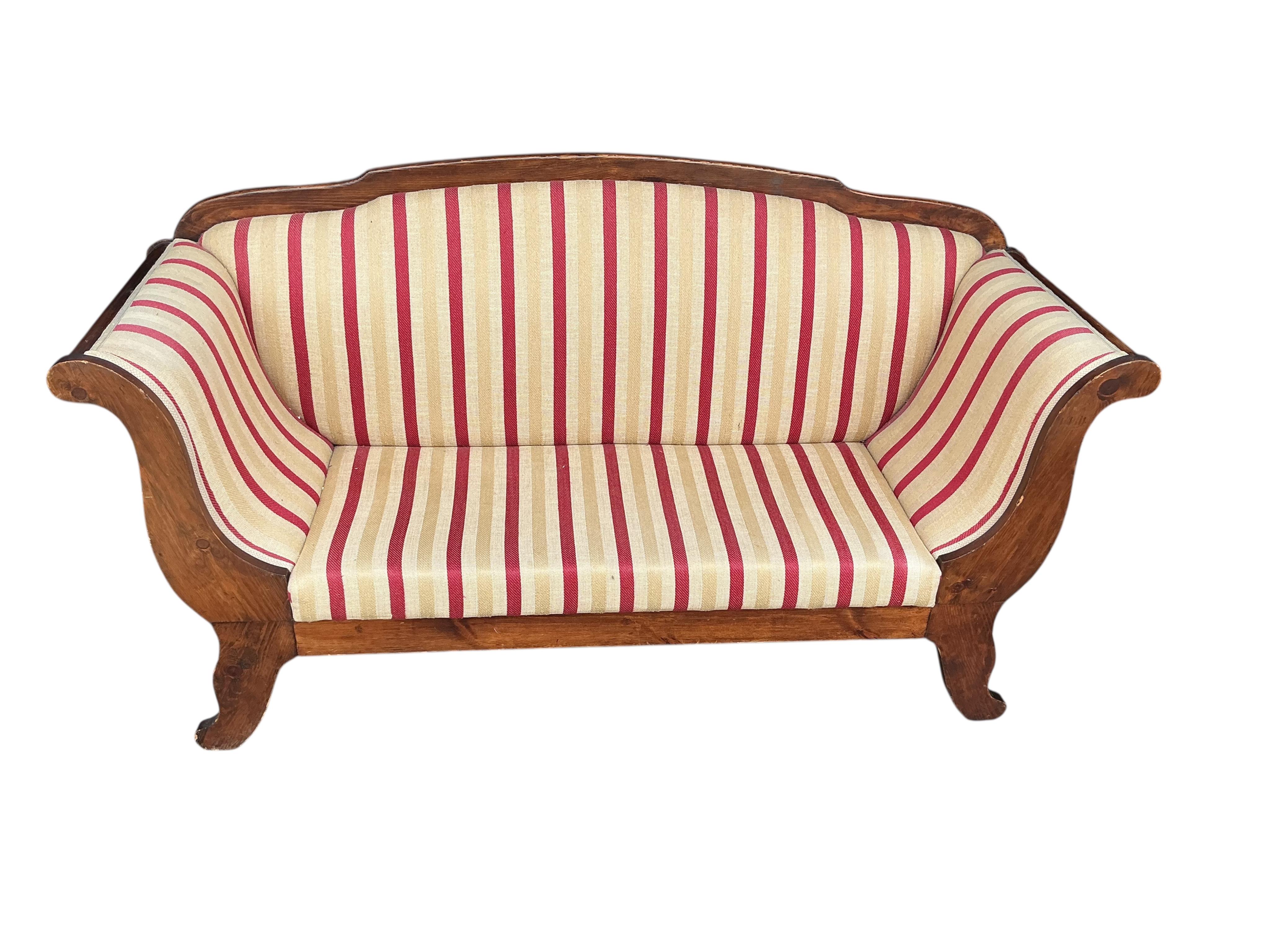 An early 19th century Continental pine scroll arm settee, width 190cm, depth 62cm, height 103cm